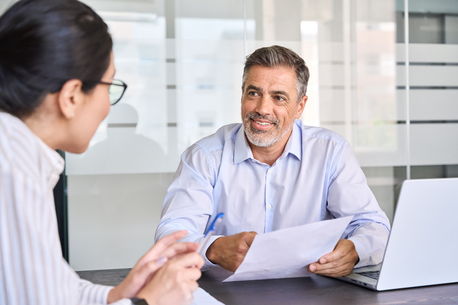 Man and woman sitting at conference table looking over documents