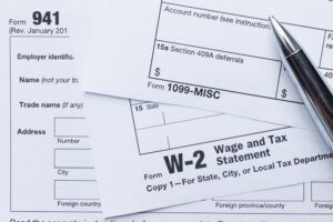 stack of employment tax papers with a pen laying on top